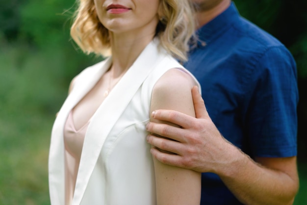 Photo jeune couple étreignant l'homme étreint une jeune femme par le soutien des épaules photo de mariage