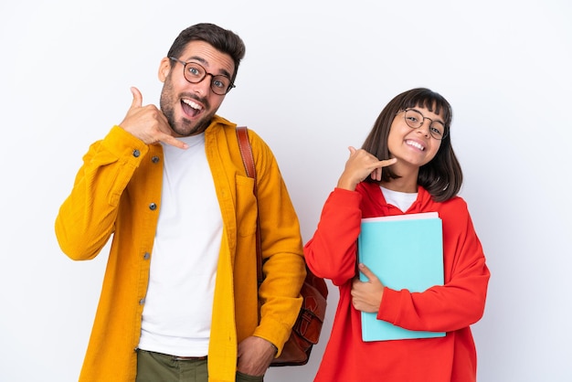 Jeune couple d'étudiants isolé sur fond blanc faisant un geste de téléphone Call me back sign