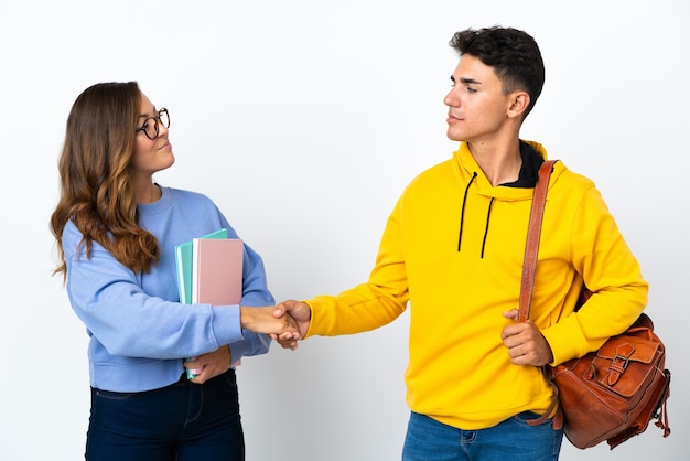 Jeune couple d'étudiants sur la poignée de main blanche après une bonne affaire