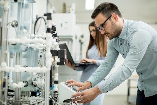 Jeune couple d&#39;étudiants travaillant au laboratoire de robotique