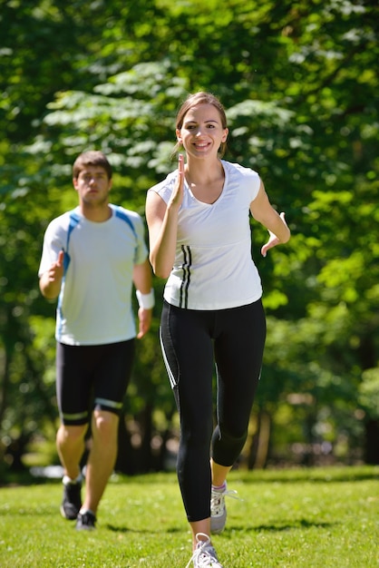Jeune couple faisant du jogging dans le parc le matin. Concept de santé et de remise en forme