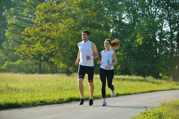 Jeune couple faisant du jogging dans le parc le matin. Concept de santé et de remise en forme