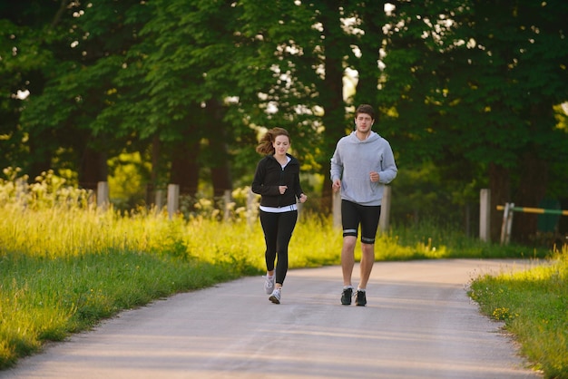 Jeune couple faisant du jogging dans le parc le matin. Santé et remise en forme.