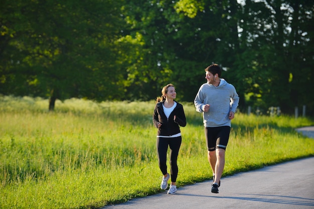 Jeune couple faisant du jogging dans le parc le matin. Santé et remise en forme.