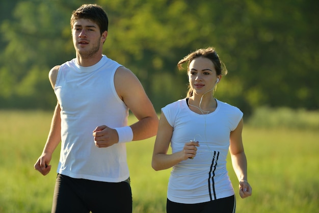 Jeune couple faisant du jogging dans le parc le matin. Santé et remise en forme.