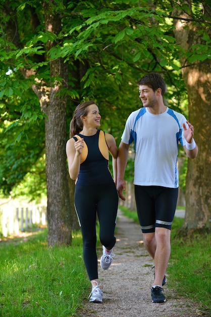 Jeune couple faisant du jogging dans le parc le matin. Santé et remise en forme.