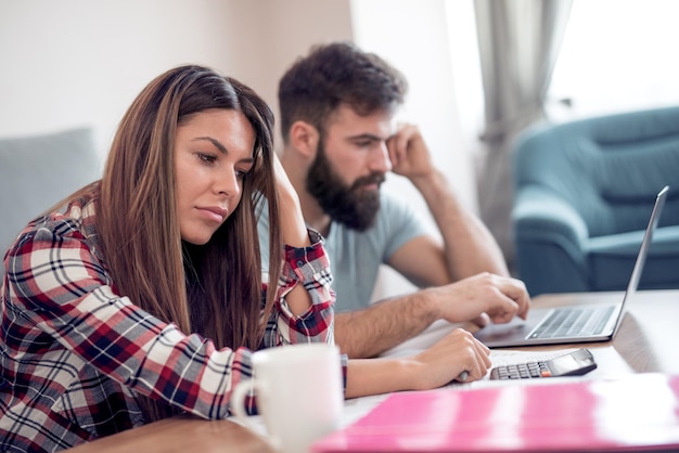 Jeune couple faisant des finances familiales à la maison