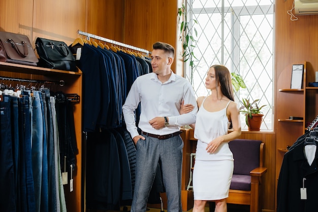 Un jeune couple fait du shopping et prend un costume d'homme.