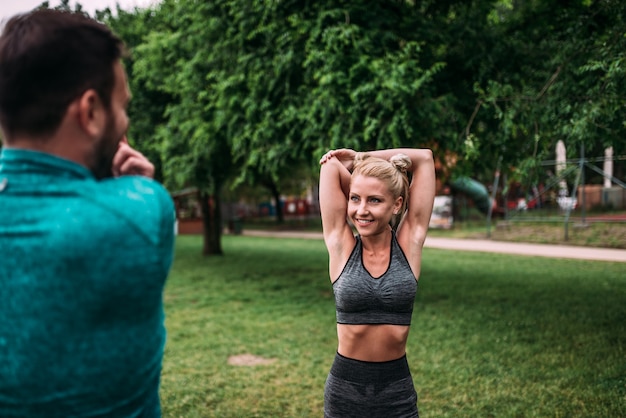 Photo jeune couple fait des exercices d'étirement à l'extérieur.