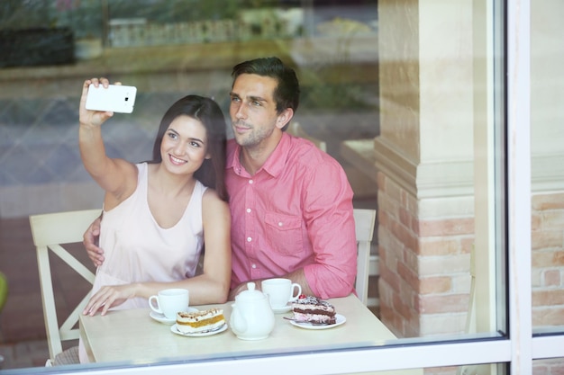 Jeune couple fait selfie au café