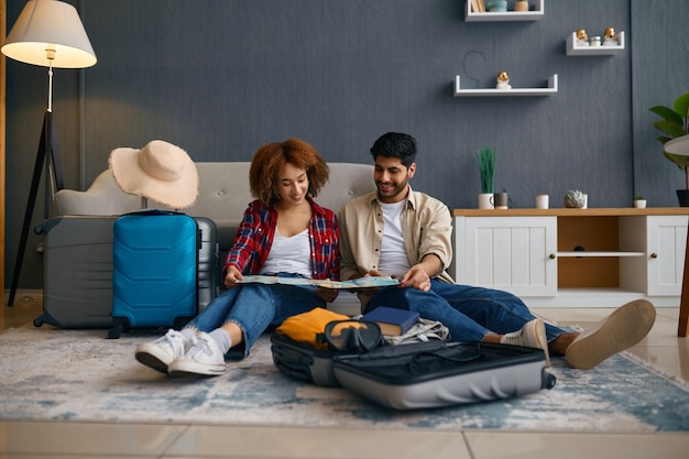 Jeune couple familial multinational planifiant un voyage de vacances en lune de miel avec carte