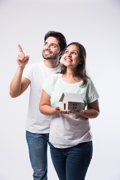Jeune couple de famille indien et concept immobilier - achat ou location, debout sur fond blanc