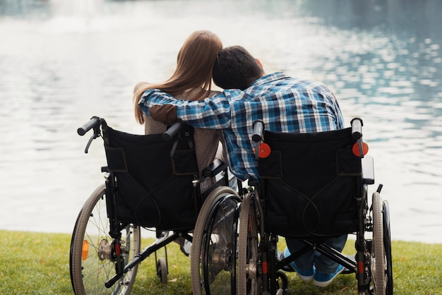 Jeune couple en fauteuil roulant dans le parc