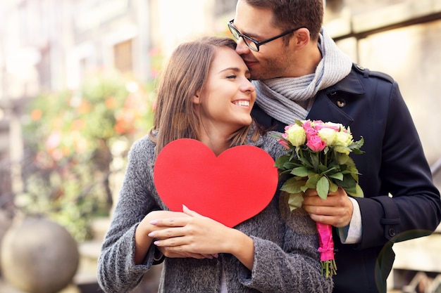 jeune couple avec fleurs et coeur