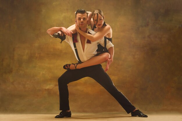 Jeune couple flexible dansant pasadoble en studio Mode portrait d'un homme et d'une femme séduisants