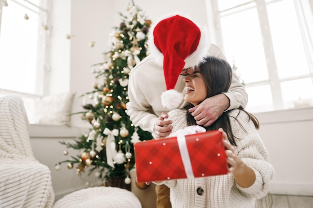 Jeune couple gai amoureux du cadeau de Noël