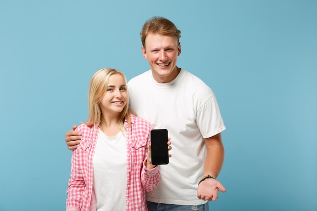 Jeune couple gai deux amis gars et femme en t-shirts roses blancs posant