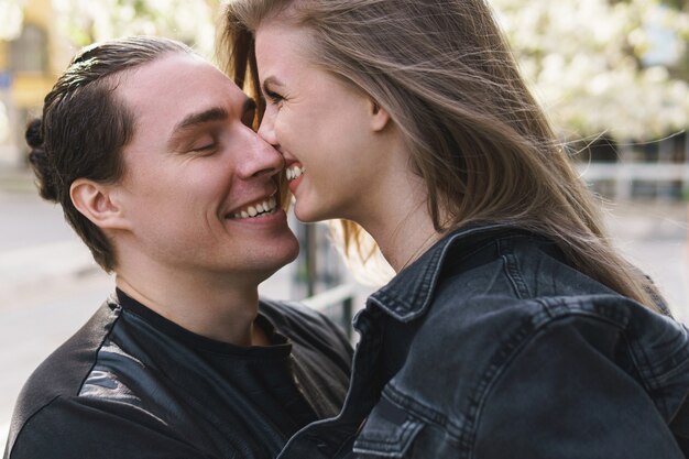 Jeune couple gai et souriant lors d'un rendez-vous à l'extérieur