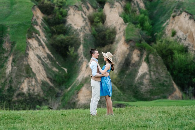 Jeune couple un gars et une fille marchent dans les collines verdoyantes de la montagne