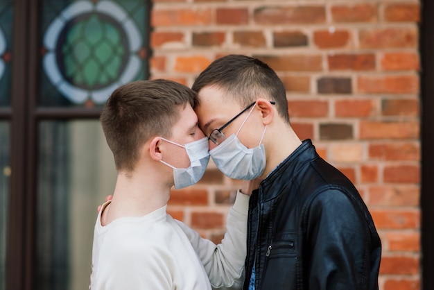 Jeune couple gay portant un masque médical étreignant la ville.