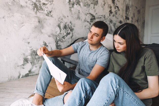 Un jeune couple gère ses finances en parcourant ses comptes bancaires