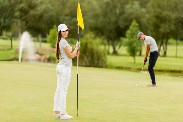 Jeune couple, golf jouant