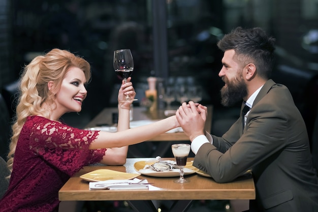 Jeune couple heureux amoureux assis au café.