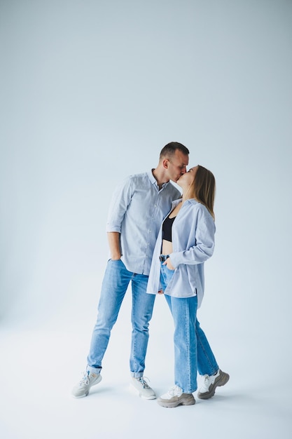 Jeune couple heureux amoureux en jeans et chemises sur fond blanc Homme et femme romantique souriant