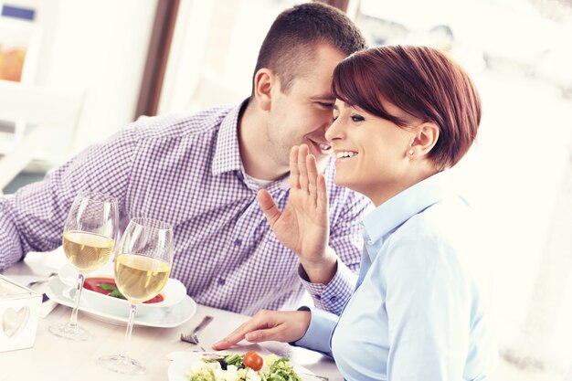 un jeune couple heureux assis dans un restaurant et parlant