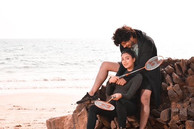 jeune couple heureux assis sur la plage modèle pakistanais indien