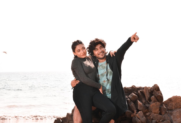 jeune couple heureux assis sur la plage modèle pakistanais indien