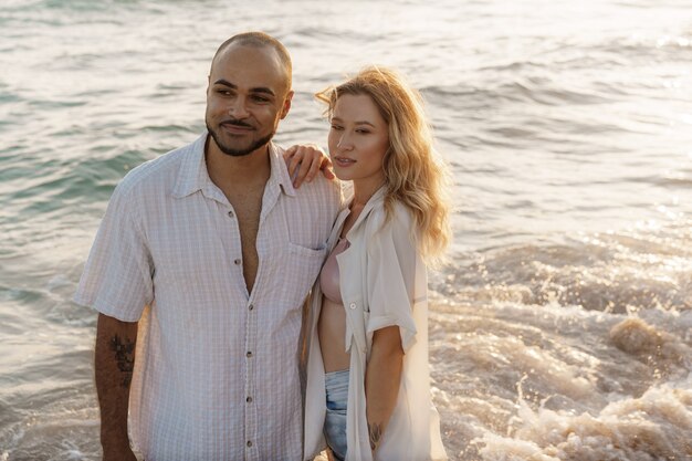 Jeune couple heureux au bord de la mer, profitant de la mer