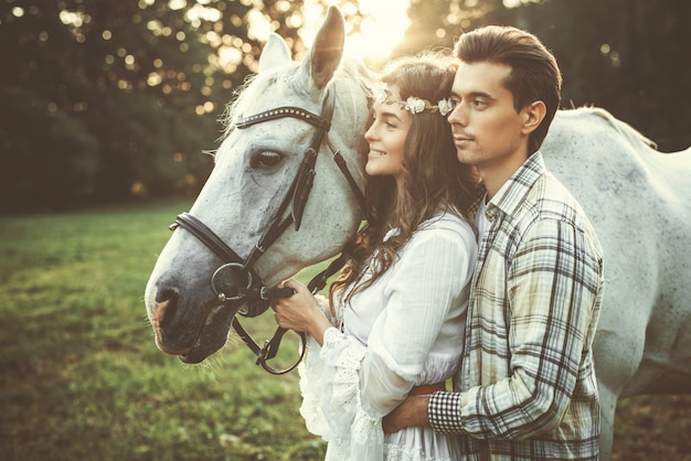 Jeune couple heureux et beau cheval
