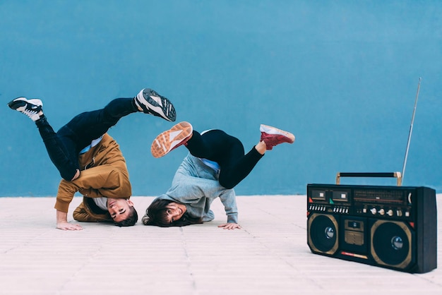 Jeune couple heureux dansant dans la rue avec une radio cassette stéréo vintage xA