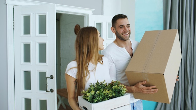 Jeune couple heureux discutant debout dans leur nouvelle maison