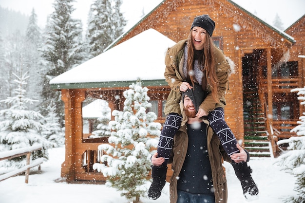 Jeune couple heureux drôle s'amusant ensemble en hiver