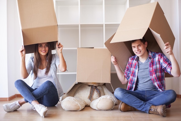 Jeune couple heureux emménageant dans leur nouvelle maison. Ils déballent et nettoient la nouvelle maison.