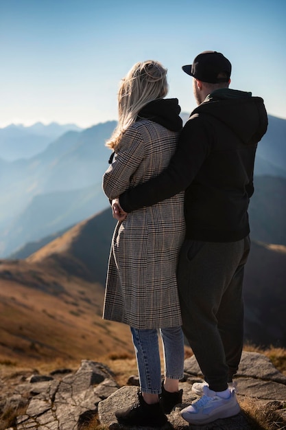 Jeune couple heureux faisant une pause lors d'une randonnée en montagne