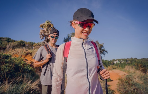 Un jeune couple heureux grimpe au sommet des montagnes près de l'océan