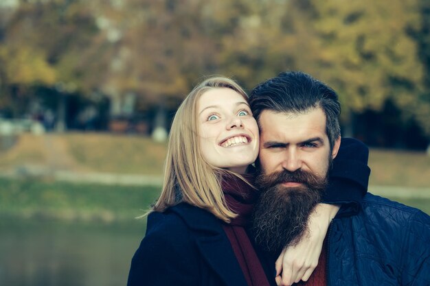 Jeune couple heureux de jolie fille et hipster homme barbu embrassant à l'extérieur dans le parc le jour de l'automne sur fond naturel