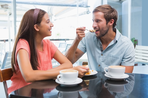 Jeune couple heureux, manger du gâteau ensemble