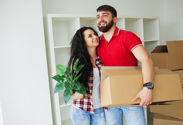 Jeune couple heureux parlant en se tenant debout dans leur nouvelle maison.