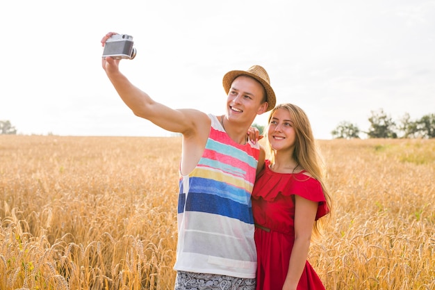 Jeune couple heureux prenant un selfie sur le terrain