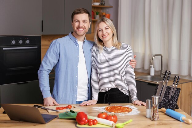 Photo un jeune couple heureux prépare une nourriture saine et savoureuse dans une cuisine moderne.