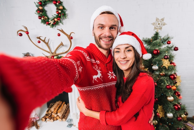 Photo jeune couple heureux près de sapin de noël