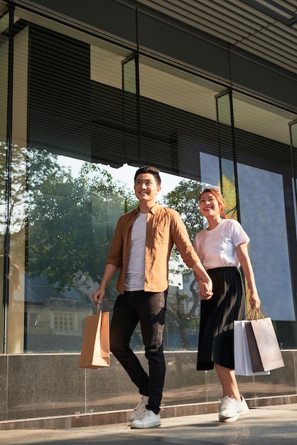 Jeune couple heureux avec des sacs à provisions dans la ville