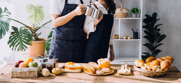 Un jeune couple heureux savoure et prépare un repas sain dans sa cuisine et lit des recettes sur son ordinateur portable