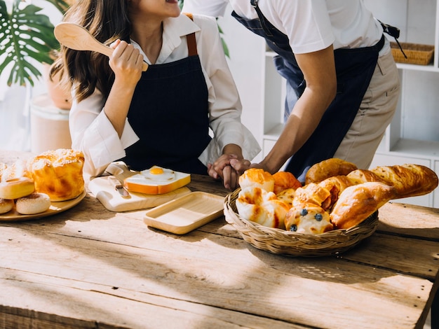 Un jeune couple heureux savoure et prépare un repas sain dans sa cuisine et lit des recettes sur son ordinateur portable