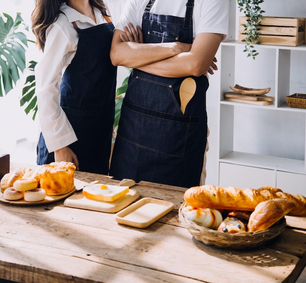 Un jeune couple heureux savoure et prépare un repas sain dans sa cuisine et lit des recettes sur son ordinateur portable