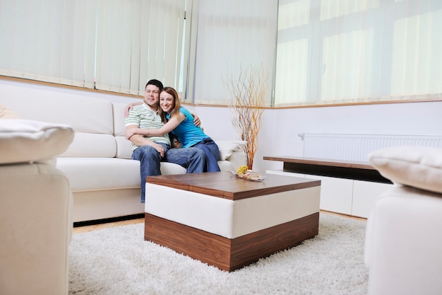 un jeune couple heureux se détend à la maison dans un salon moderne et lumineux